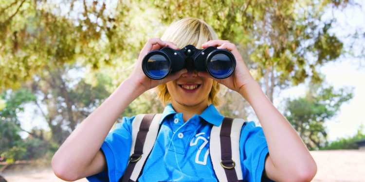 Boy with binoculars and backpack