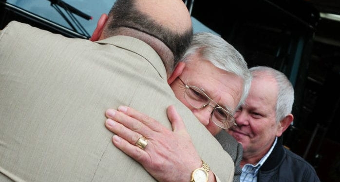 Timothy Berry receives a hug from Wieslaw Szczutowski as Ludwik Branach looks on. Szczutowski and Branach were honored Saturday, May 7 for their heroism the week before, helping Berry and his son out of car accident just moments before it was engulfed in flames. — Photo by Michael Hallisey/Spotlight