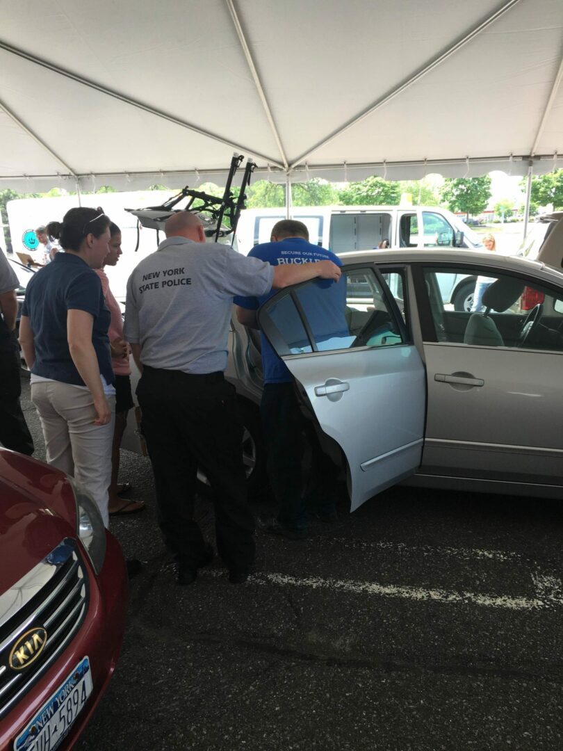 Bill VanAlstyne checks out a car at the seminar to make sure the seatbelt and car seat are installed correctly.