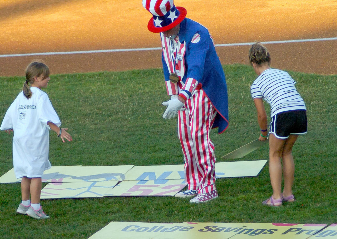 "Sammy" helps two young contestants during a between-innings contest. Rob Jonas/Spotlight