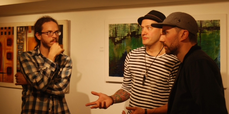 Tommy Watkins, center, talks from inside the Upstate Artists Guild prior to its closing. (photo by Ali Hibbs/ The spot)