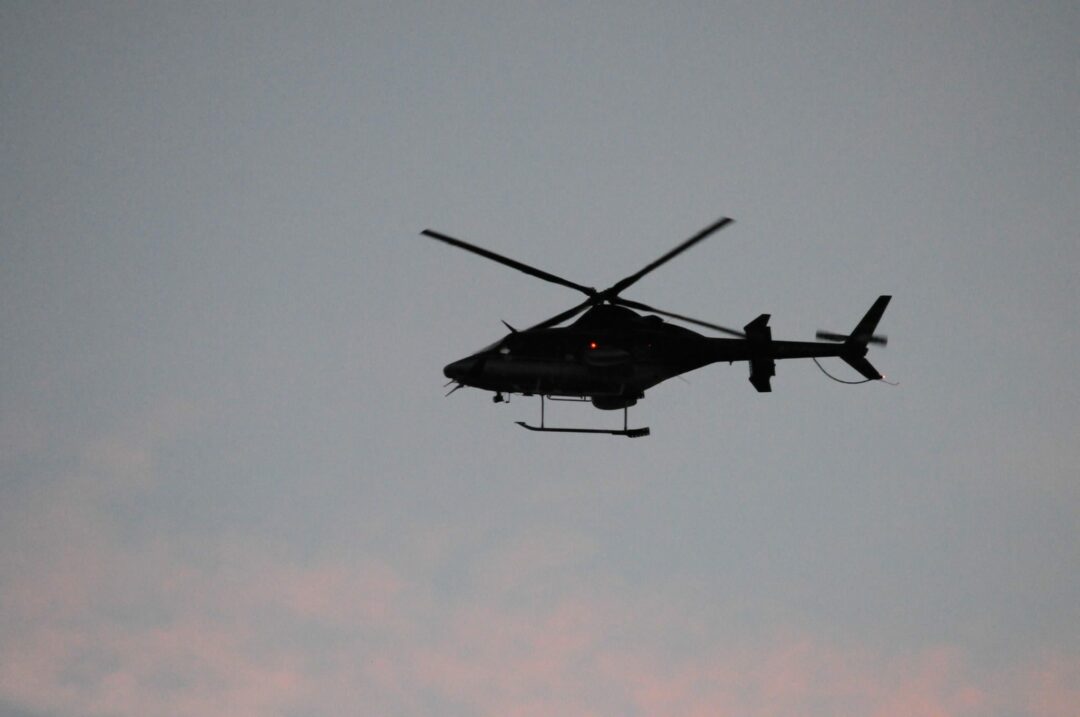 A helicopter flies over Crossgates Mall early Saturday evening as police continue their investigation into an alleged shooting which took place earlier in the afternoon.
