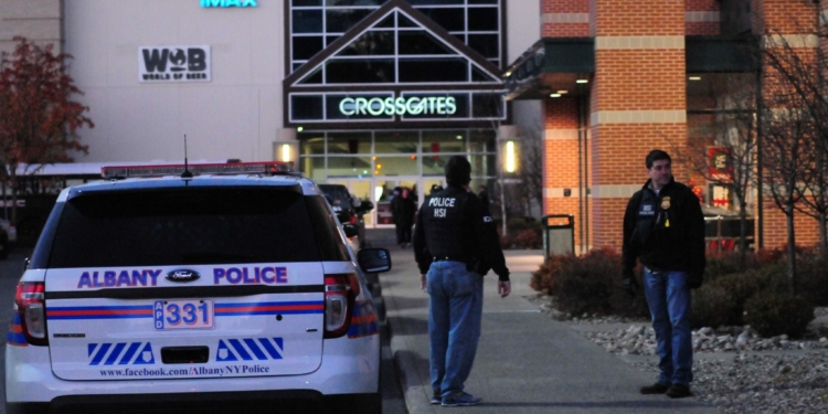 A pair of police officers stands outside the entrance to Dick's Sporting Goods at Crossgates Mall Saturday afternoon after an alleged shooting took place.