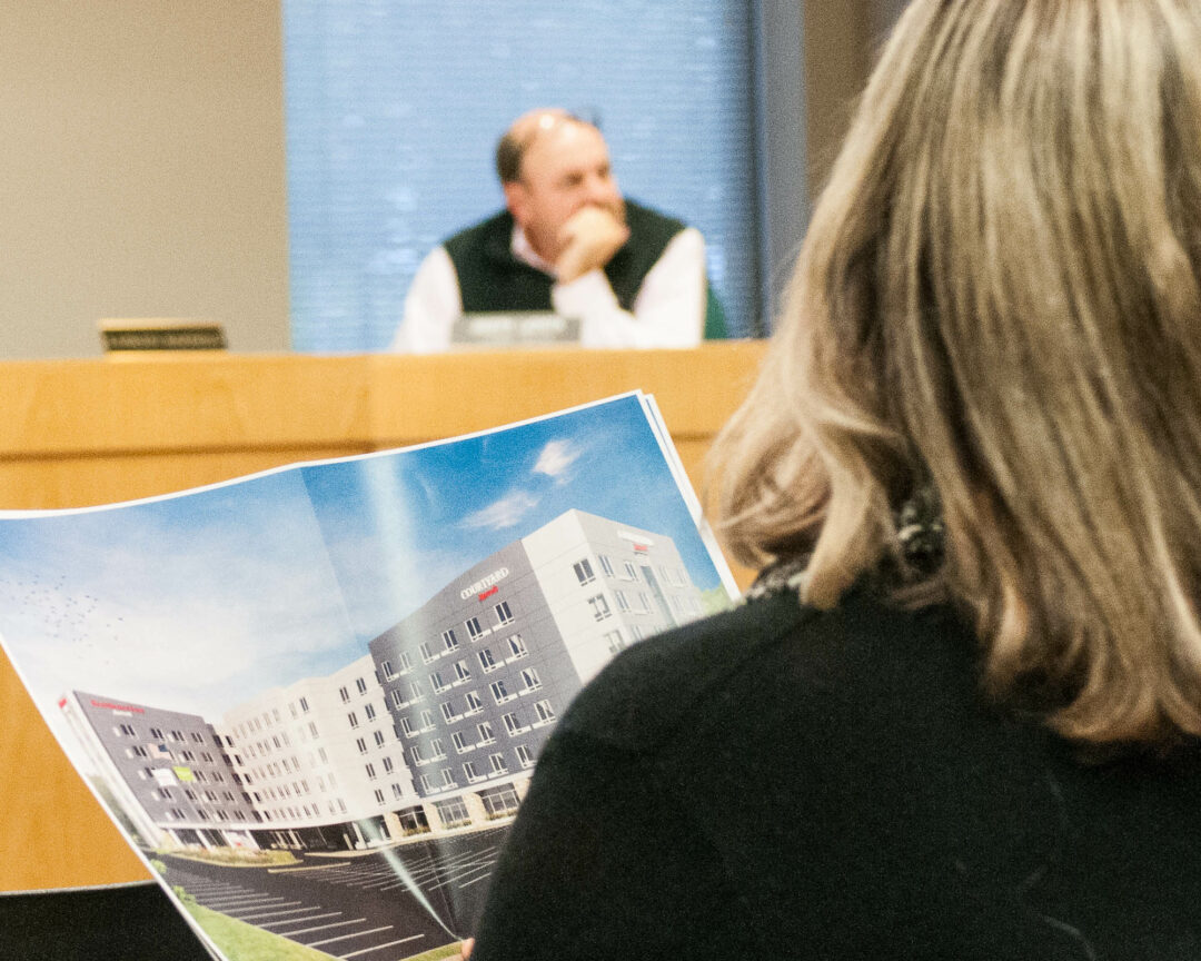One resident looks over a proposed plan at a recent Colonie Planning Board meeting. Despite grumbling over development and traffic congestion, nearly everyone polled by Siena College this year loves living here.
(Photo by Jim Franco / Spotlight News)