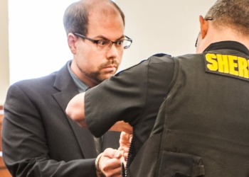 A corrections officer puts handcuffs on Brian Tromans after a judge upped his bail by $25,000 (Photo by Jim Franco/Spotlight News)