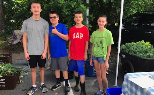 Ryan Burns, Aden Hass, Owen Karmel, and Aidan Stickan help at the July 15 Delmar Farmers Market.  (Photo submitted)