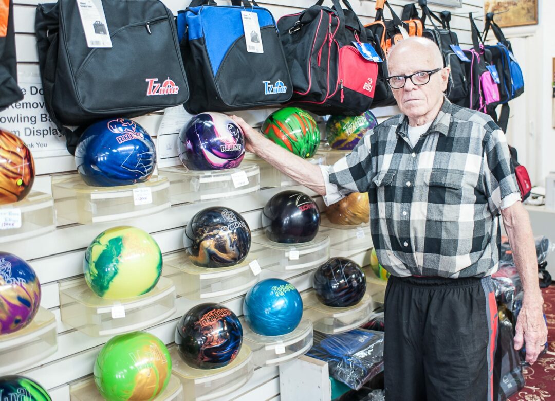 Bob Daubney stands next to his bowling balls at his shop on Route 2 (Photo by Jim Franco/Spotlight News)