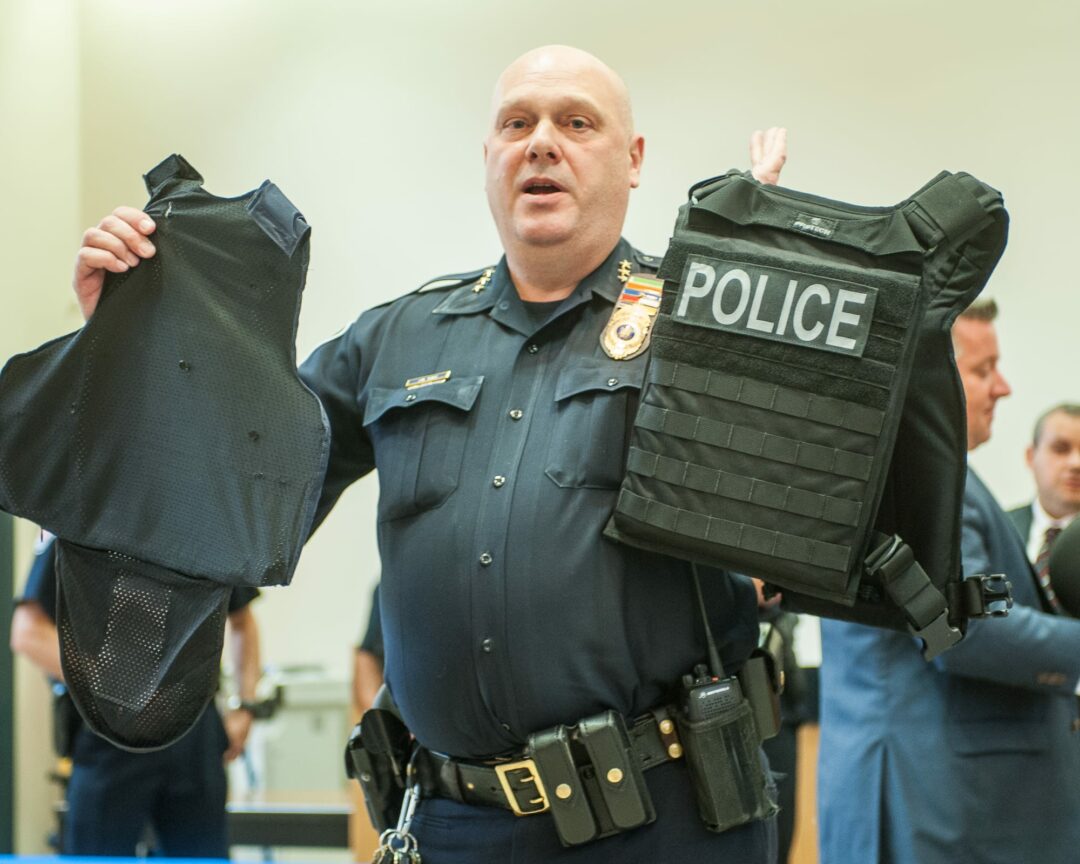Colonie Police Chief Jonathan Teale demonstrates the difference between the old vests and the new vests (Photo by Jim Franco/Spotlight News)