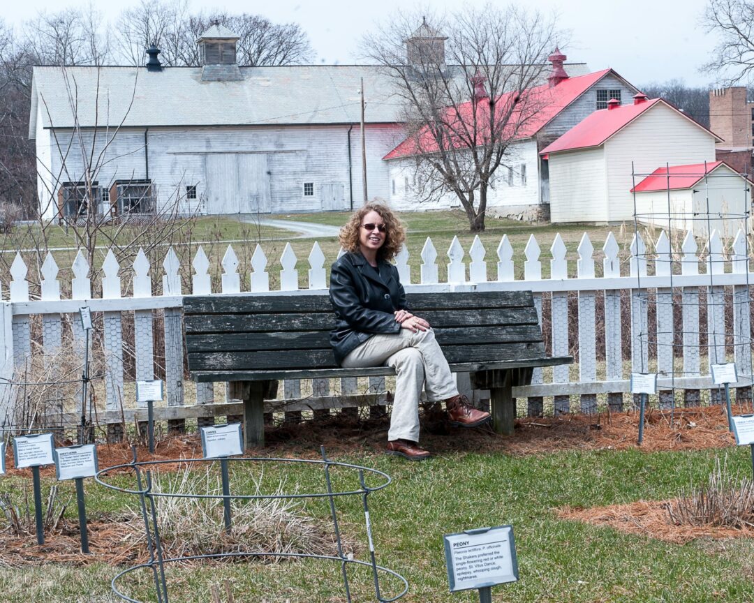 Watervliet Shaker National Register Historic District Executive Director Starlyn D’Angelo in an herb garden at the Shaker Site. In the background is the iconic 1915 barn.
(Jim Franco/Spotlight News)