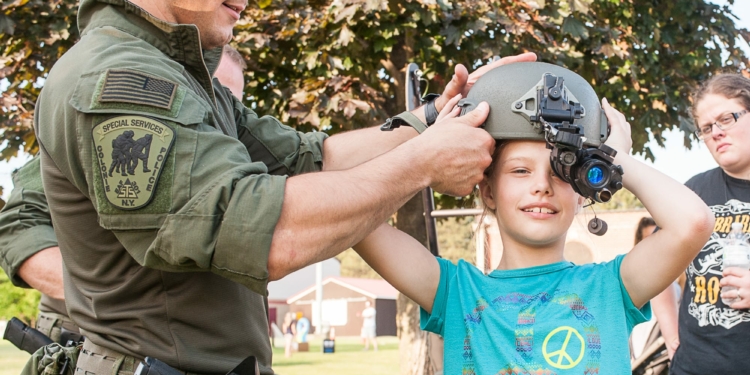 A Colonie police officer lets a child look through a helmet equipped with an infrared camera. (Jim Franco/Spotlight News)