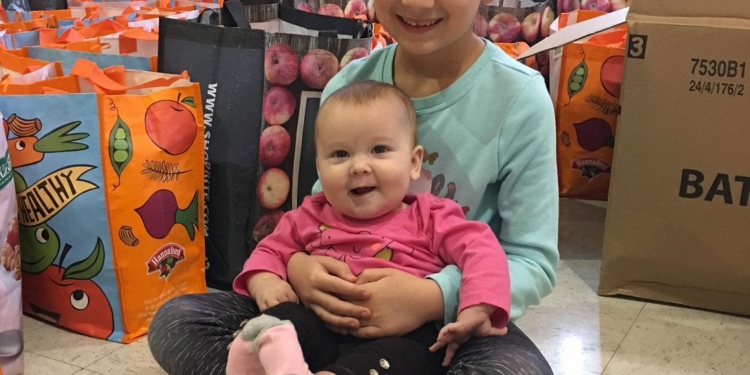 Vanessa Long cuddles sister Ava in front of goody bags.
Photo Submitted
