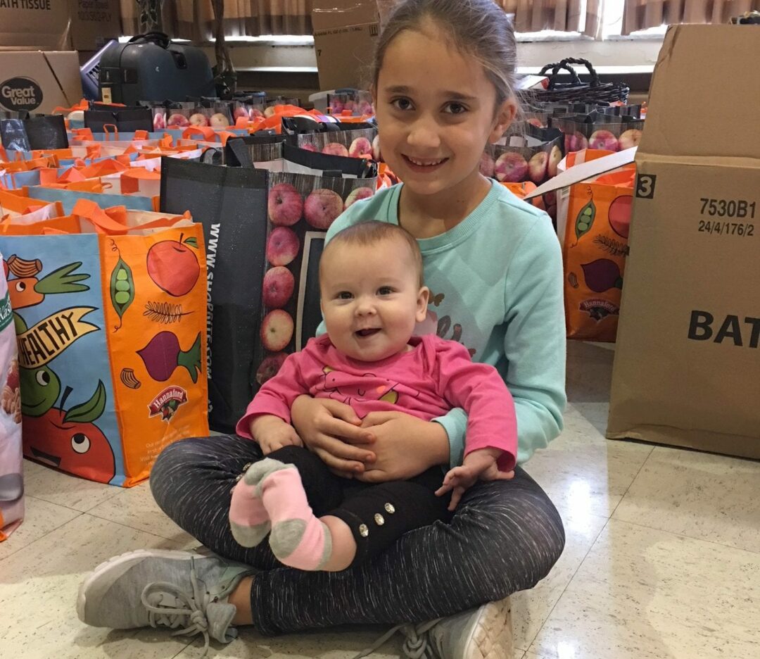 Vanessa Long cuddles sister Ava in front of goody bags.
Photo Submitted