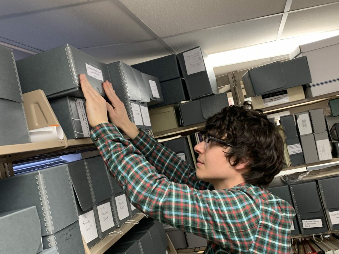 Technology Assistance Andrew Ward goes through one of 130 boxes in the library’s archives, all of which need to be scanned for preservation. Diego Cagara / Spotlight News