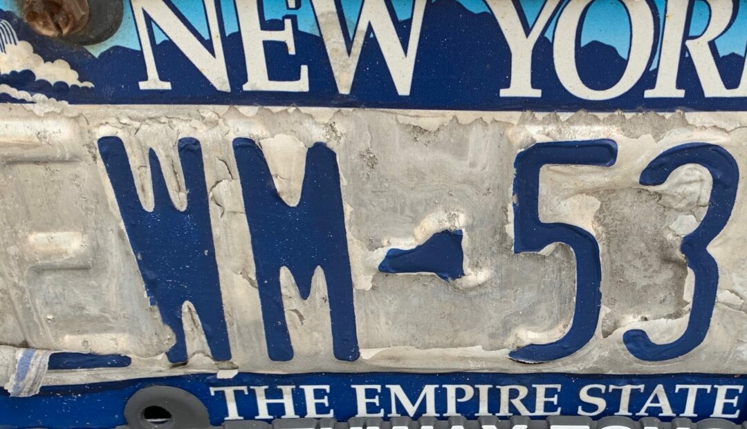 An Empire blue and white license plate is showing signs of age (Jim Franco/Spotlight News)