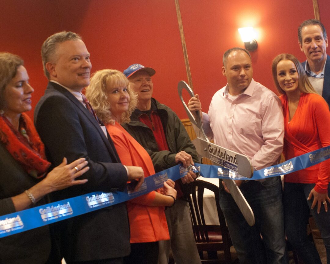 Orchard Tavern owner Kristopher Monforte, third from right in pink, is supported by his wife, Katelyn, second from right, and local politicians as well as the Guilderland Chamber of Commerce during the restaurant's ribbon-cutting ceremony to mark the second location's opening. Diego Cagara / Spotlight News