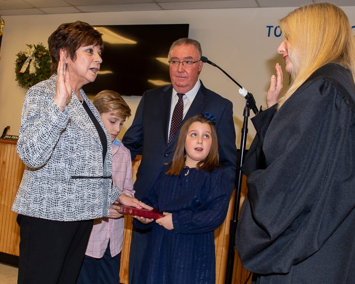 Colonie Town Supervisor Paula Mahan is administered the oath of office by state Supreme Court Judge Margaret Walsh while her grandchildren hold the Bible and her husband Joe stands by. (Jim Franco/Spotlight News)