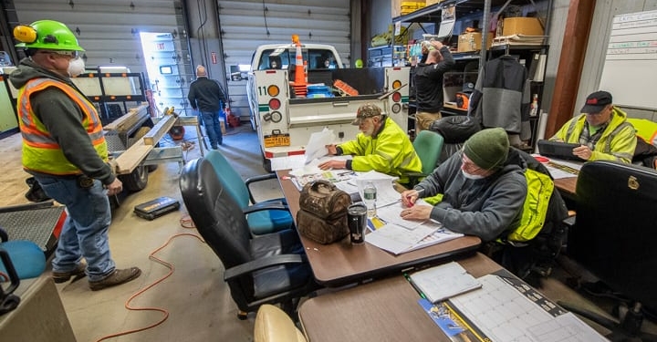 Workers at the Division of Pure Waters Collection Section squeeze by a utility truck to do paperwork while another worker was cutting wood to fix a trailer. 


Jim Franco / Spotlight News