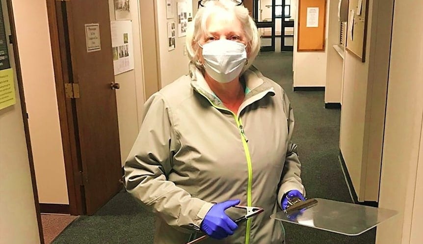 Bethlehem Town Clerk Nanci Moquin wore gloves and masks while using a clipboard attached to a long stick to help issue a couple their marriage license this week. Provided photo