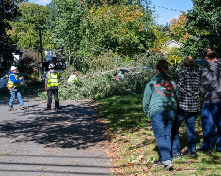 Debbie Henry and her two children watch as crews clean up a tree that fell on her car at the corner of Delsmere and Kenwood avenues in Bethlehem (Jim Franco/Spotlight News)