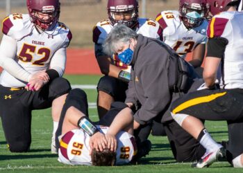 Colonie High School Athletic Trainer Aimee Brunelle tends to an injured football player during a game against Schenectady. (Jim Franco / Spotlight News)