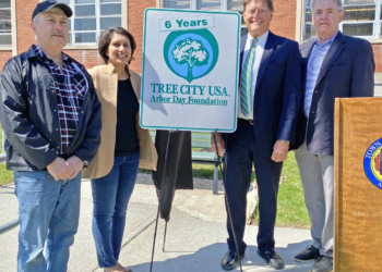 (From left) Timothy Barnard, a member of the town Conservation Advisory Council, CAC Chairwoman Zainab Magdon-Ismail, Supervisor Peter Crummey and Town Board member Jeff Madden hold a Tree City USA sign. 
Photo submitted