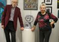 Art Associates Gallery Inc. owners Attila and Kinga Zalavary posing near artwork made by members of the United Artist Guild, Friday, May 5.