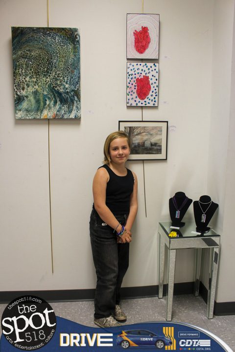 Molly Francis posing next to her heart pieces on view at Art Associates Gallery Inc. Friday, May 5.